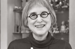 お洒落のポイントは眼鏡。その日の気分でかけかえる。手にしているのは『魔女の宅急便』の主人公キキの相棒、猫のジジのぬいぐるみ。